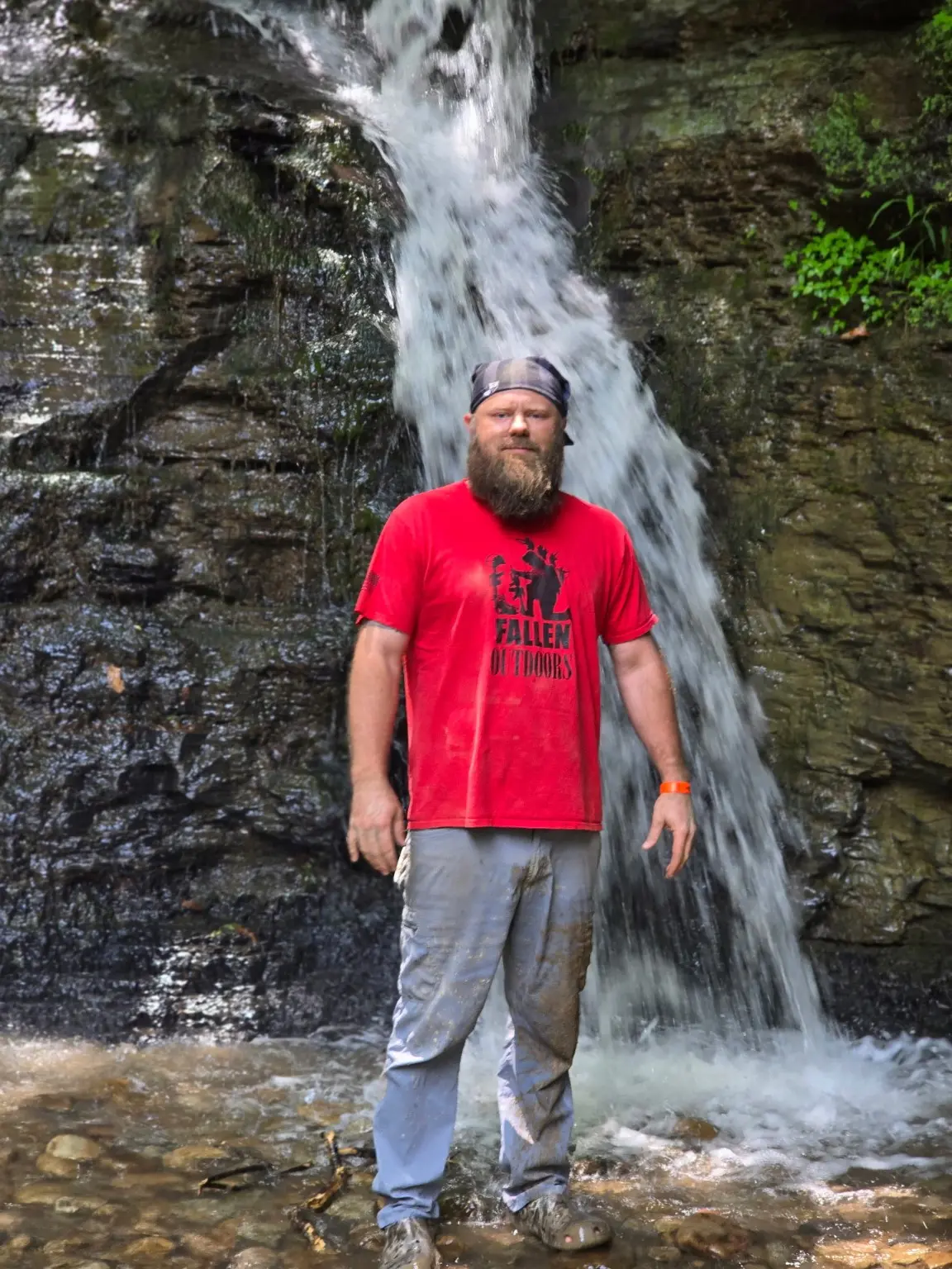 Garrett Guetersloh standing outdoors in front of a waterfall